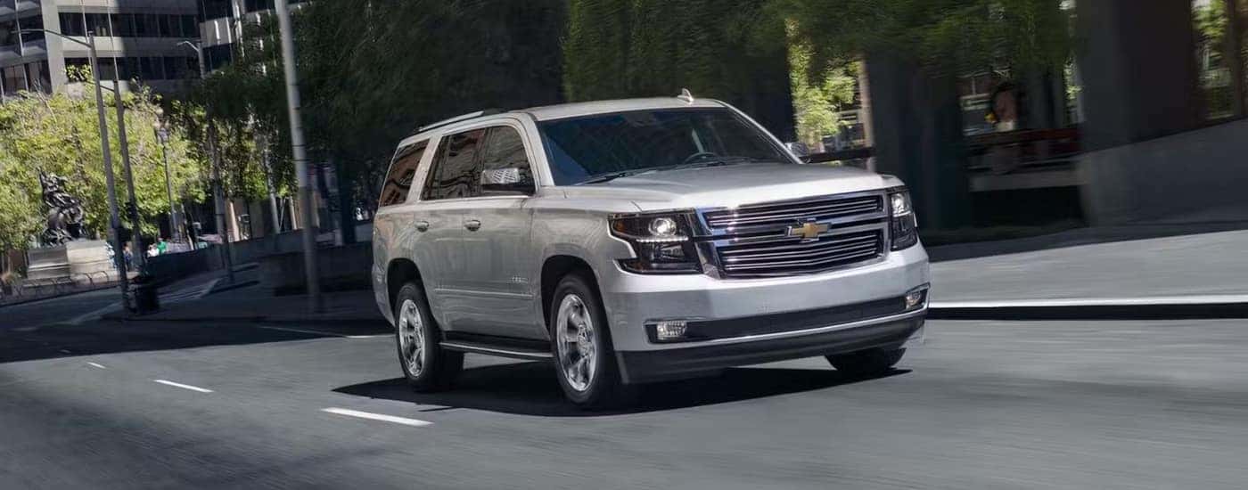 A silver 2019 Chevy Tahoe for sale driving on a city street.