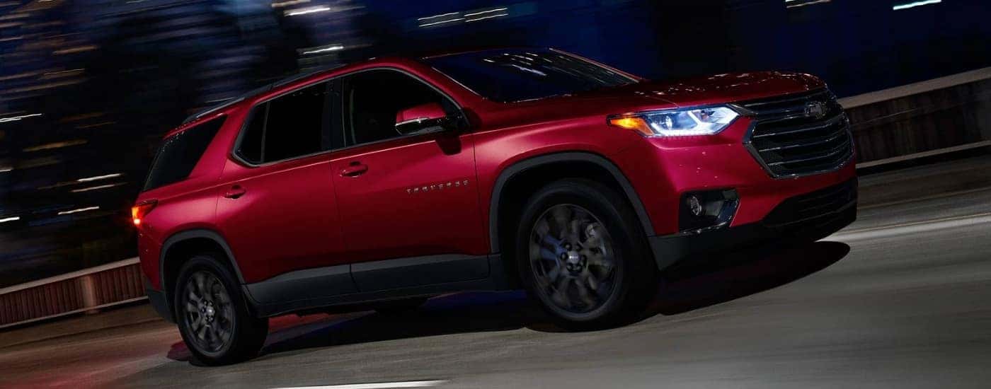 A red 2019 Chevy Traverse for sale driving at night.