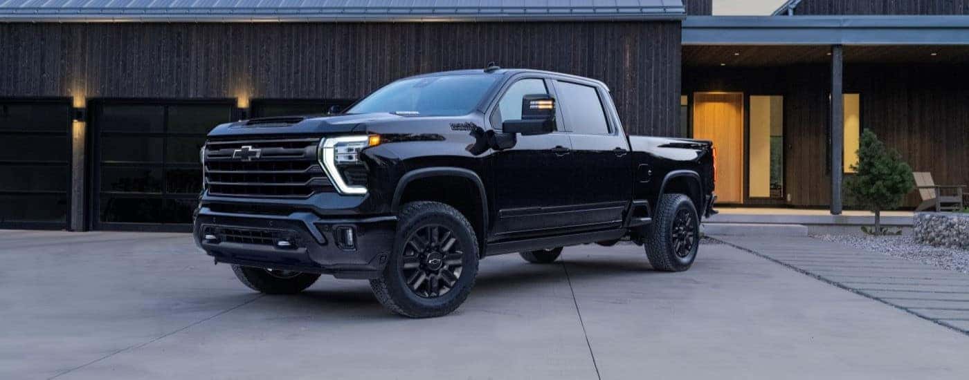 A Black Used 2024 Chevy Silverado 2500 HD High Country parked in a driveway