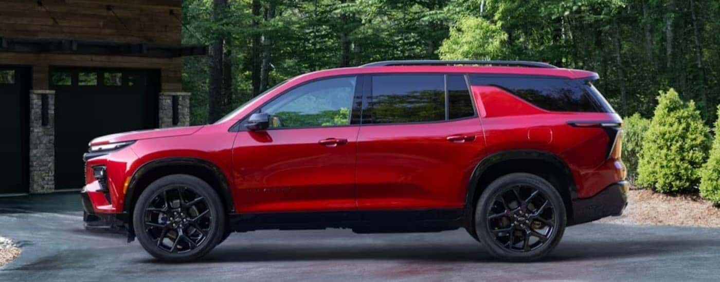 A red 2024 Chevy Traverse RS parked on a driveway.
