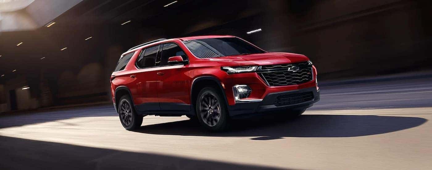 A red 2021 Chevy Traverse from the side after leaving a dealer that has a used Chevy for sale near High Point.