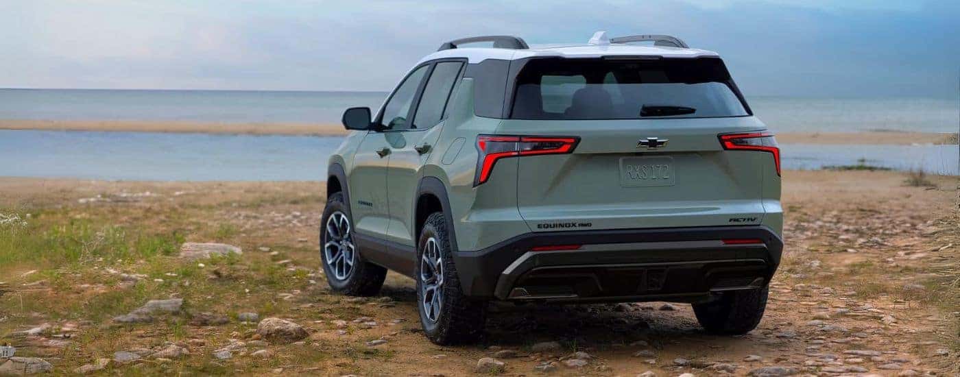 Rear of a green 2026 Chevy Equinox parked near a lake.