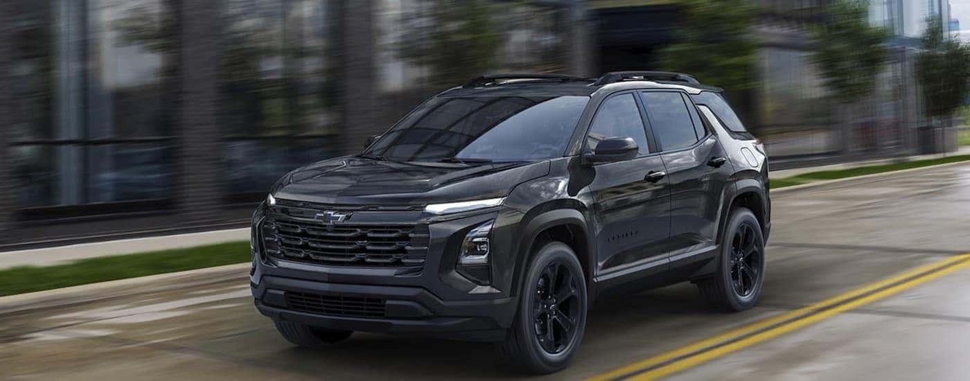 Black 2026 Chevy Equinox for sale near Winston-Salem driving down a city street.