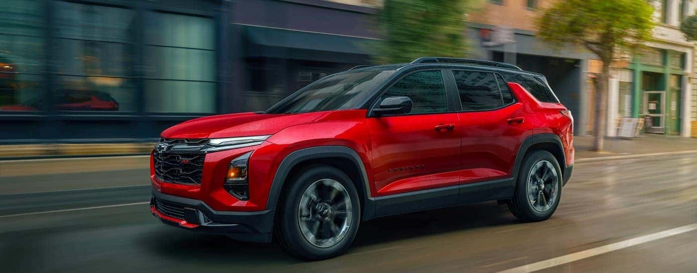 Red 2026 Chevy Equinox RS driving down a street.