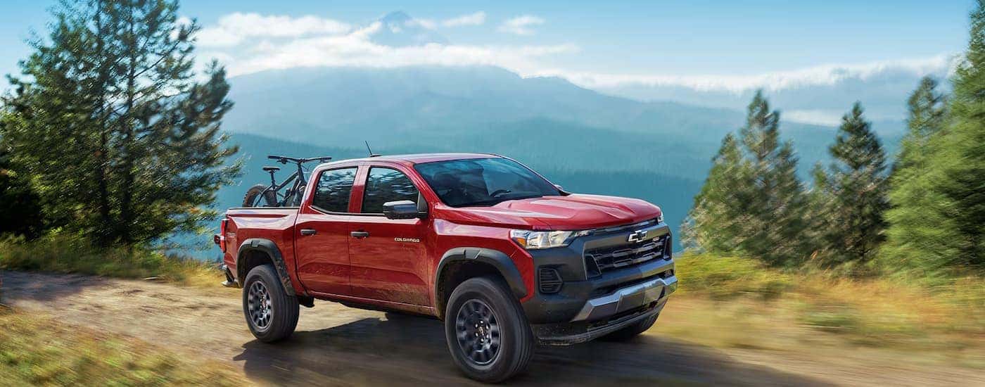 A red 2025 Chevy Colorado off-roading on a trail