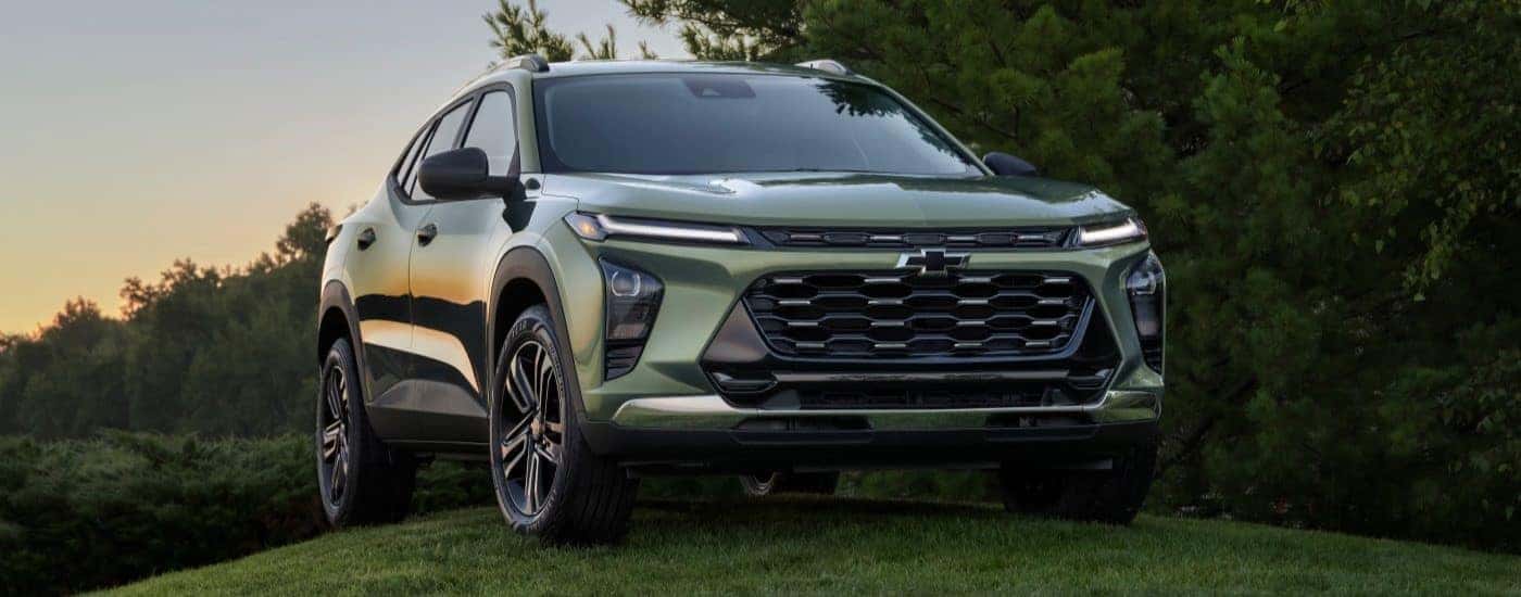 A green 2025 Chevy Trax ACTIV parked on a grass hill