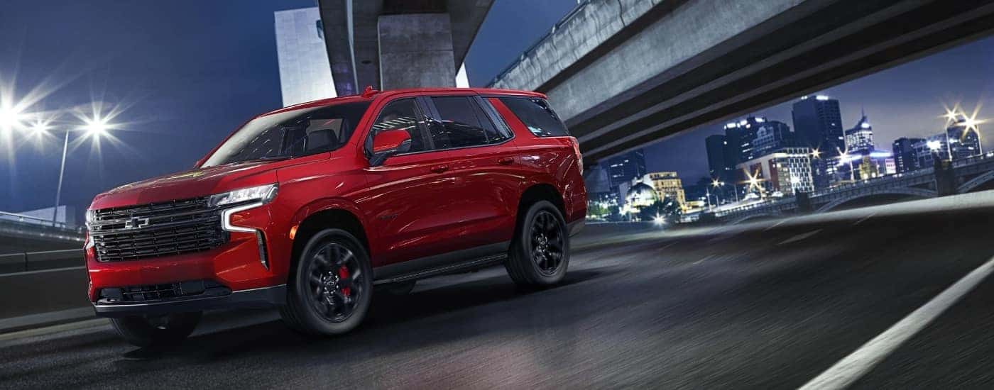 A red 2023 Chevy Tahoe from the side.