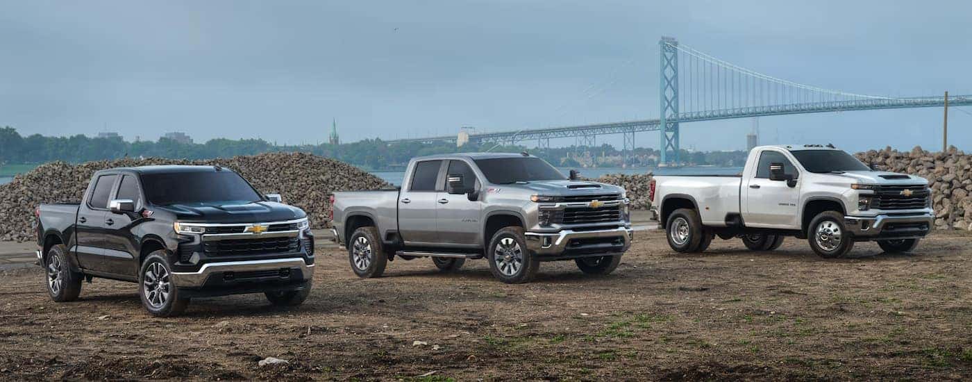 Three 2025 Chevy Commercial Trucks parked off-road