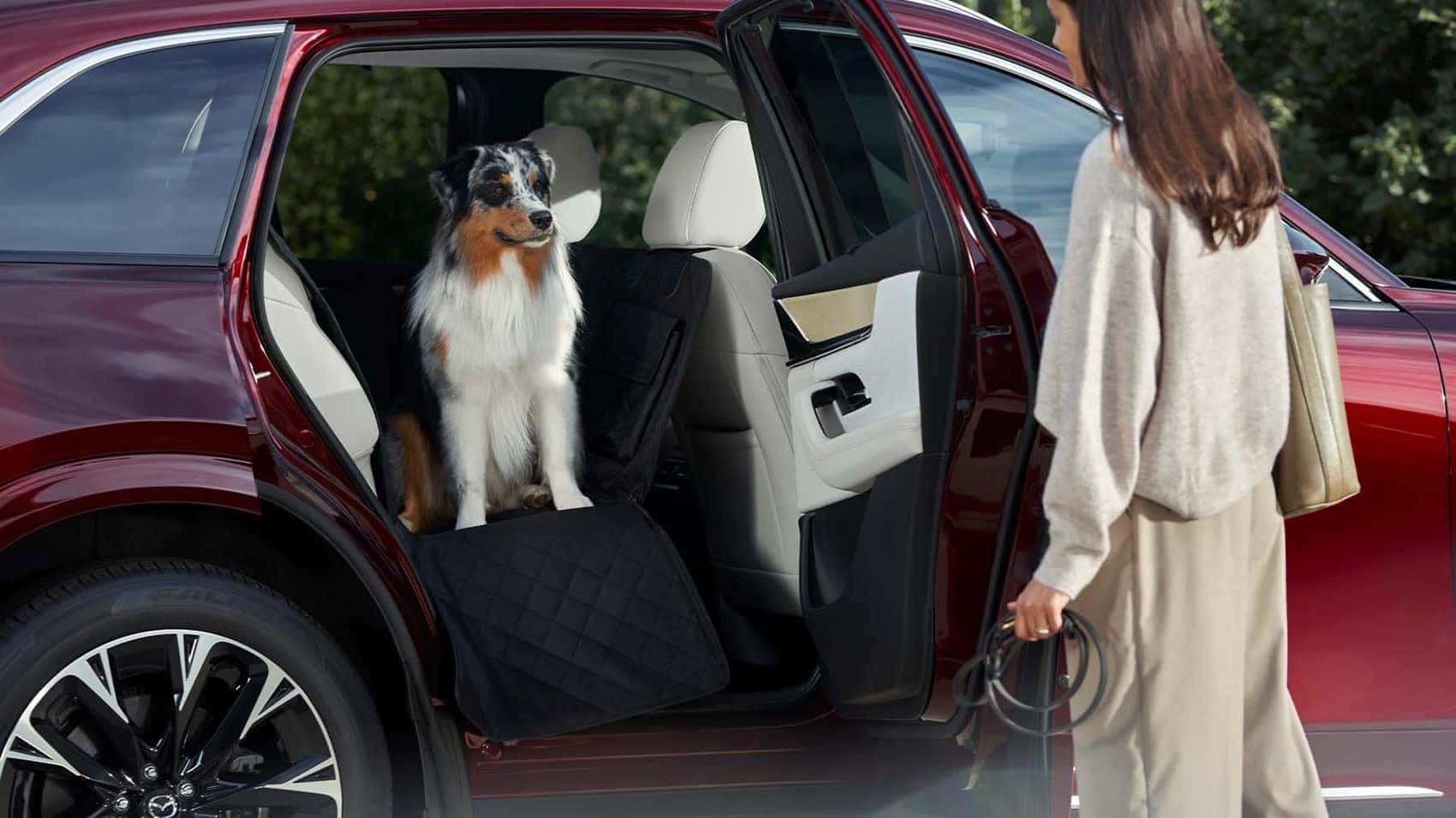Woman getting her dog out of her Mazda vehicle