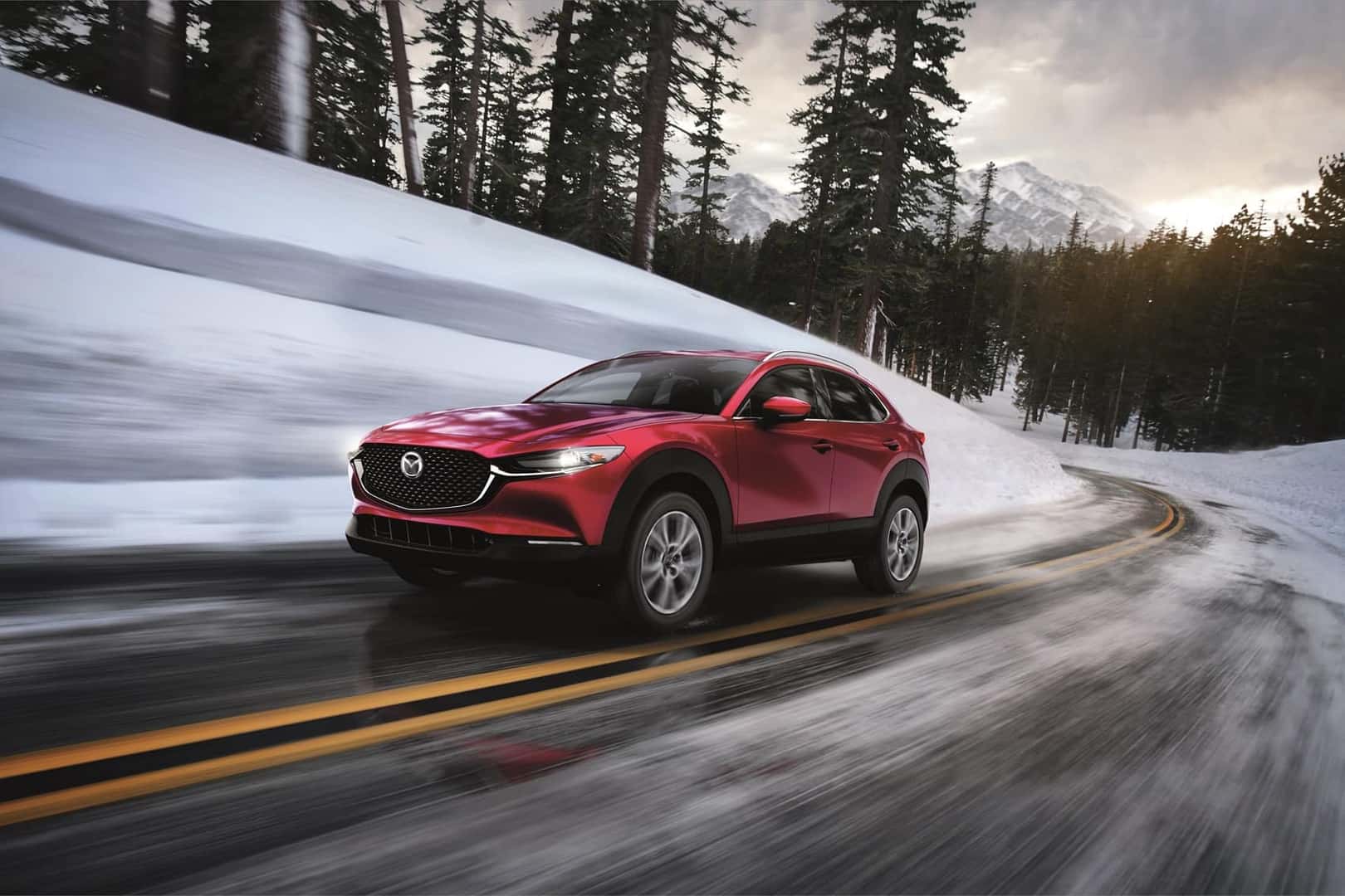 Red Mazda CX-90 driving in snow 