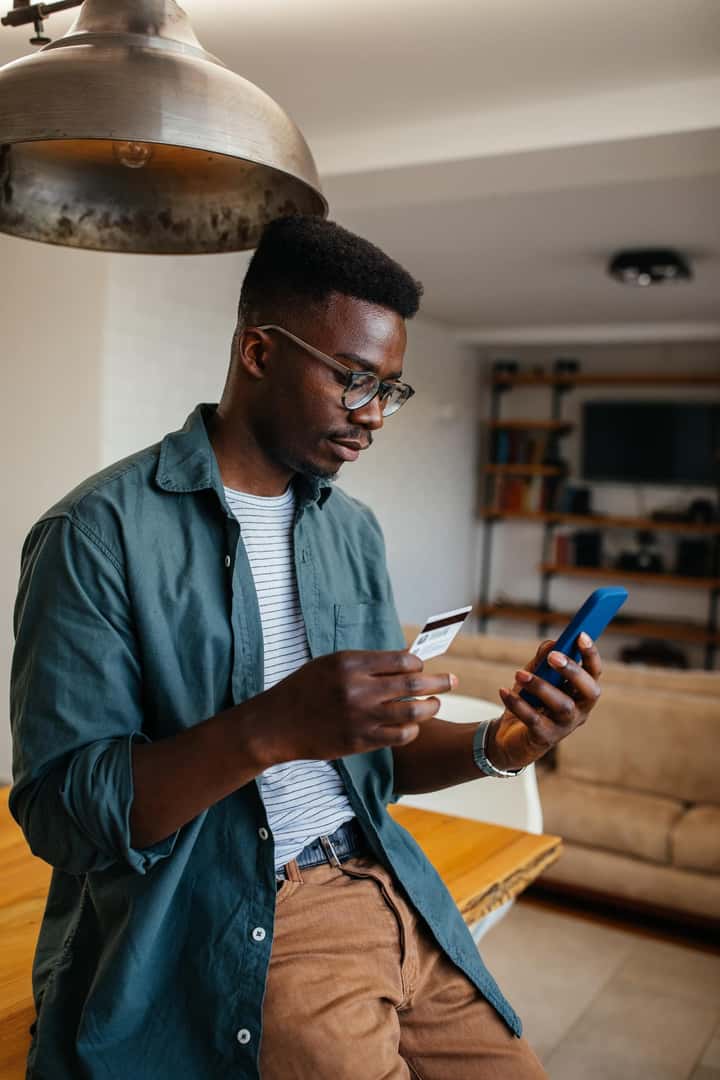 Man holding credit card and cell phone