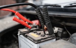 Close-up of a car battery installed under the hood of a vehicle, showing clear terminals and a clean, secure setup