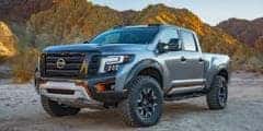 silver nissan truck against moutain background