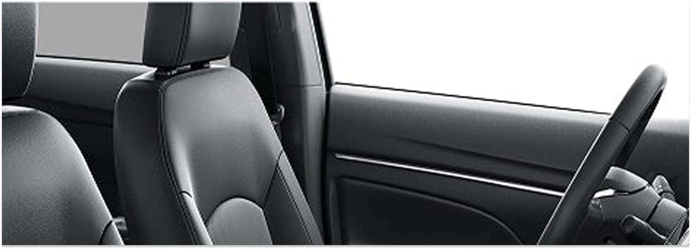 Black front bucket seat and steering wheel inside a 2026 Mitsubishi Outlander Sport interior.