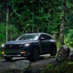 A Mazda CX-50 in the forest, one model available with Mazda lease deals
