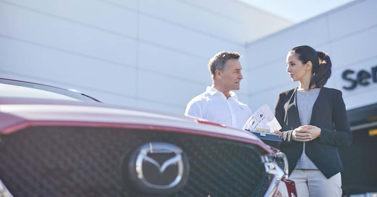 Woman speaking with a salesperson about Mazda warranty coverage
