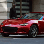Man walking toward a pre-owned Mazda car