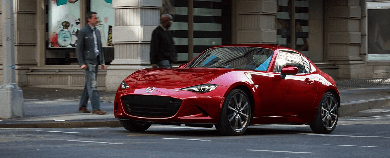 Man walking toward a pre-owned Mazda car