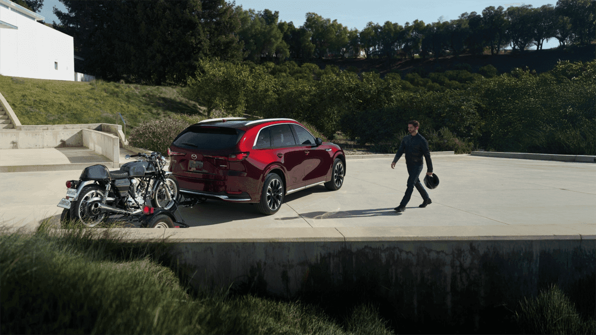 Person walking toward the 2026 Mazda CX-90 PHEV