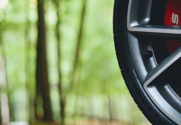 up close of car tire parked in front of forest